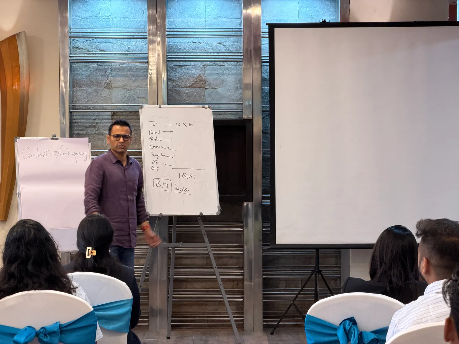 Trainer mapping media channels on a whiteboard during a workshop