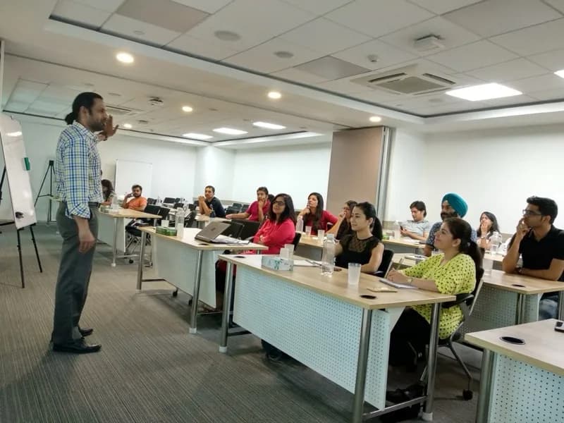 Trainer leading an in-house corporate session with professionals at desks